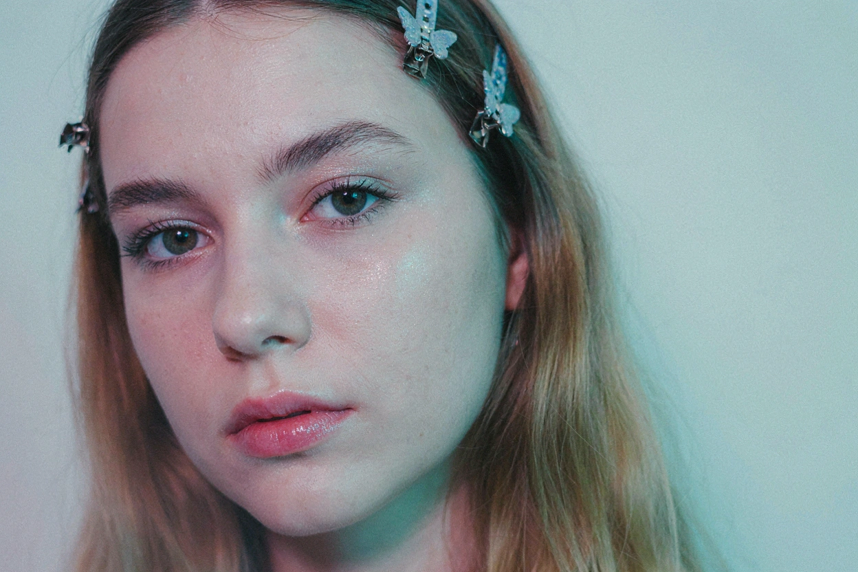 Portrait avec pinces papillons dans les cheveux et maquillage glitter